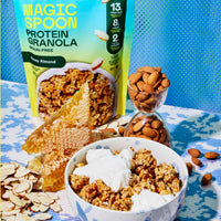 Magic Spoon Protein Granola Honey Almond flavor pouch with granola served in bowl with yogurt, almonds, and honeycomb display