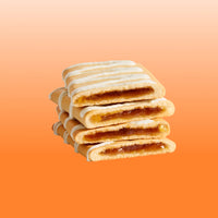 Stack of four cinnamon brown sugar pastries with white frosting stripes on orange background.