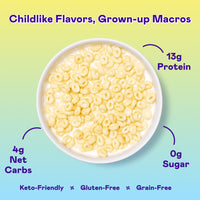 White bowl filled with frosted ring-shaped cereal pieces in milk on yellow-to-blue gradient background.