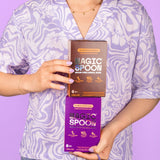 Person holding boxes of Cocoa Peanut Butter and Cookies and Cream Magic Spoon Bars