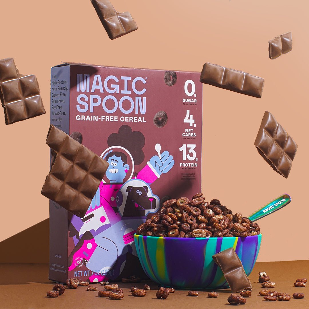 Magic Spoon grain-free cocoa cereal box with bowl of cereal and chocolate pieces on tan background.